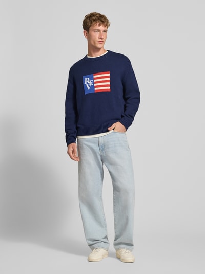Männermodel trägt Regular Fit Strickpullover aus Baumwoll-Mix von REVIEW mit Motiv-Stitching, Dunkelblau, Rundhalsausschnitt, Ganzkörperansicht von vorne