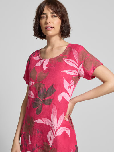 Vrouwenmodel draagt knielang dames jurk van ZABAIONE, mix van katoen en linnen, recht model, all-over look, ronde hals, model 'Pi44araa', roze met bloemenprint, textuur met zichtbare vezels, ruglengte maat S 91 cm, borstwijdte 47 cm, mouwlengte 7 cm, detailopname bovenlichaam.