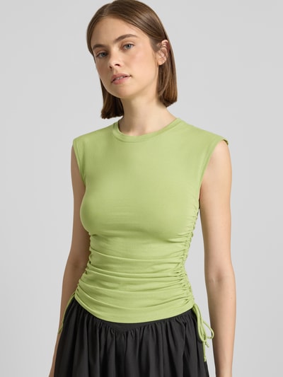 Frauenmodel trägt Trägertop mit seitlichen Raffungen Modell 'GURI' von Topshop aus Baumwoll-Elasthan-Mix, Slim-Fit, Rundhalsausschnitt, Rückenlänge bei Größe S 54 cm, hellgrün, glatte Textur, Ganzkörperansicht von vorne.