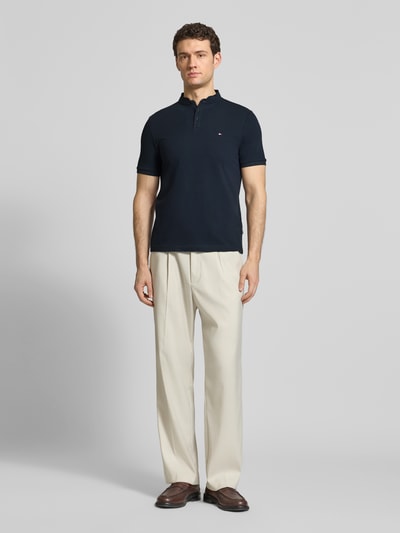 Mannenmodel draagt Regular Fit Poloshirt met opstaande kraag van HECHTER PARIS, puur katoen, knoopsluiting, labelstitching, ruglengte maat M 67 cm, donkerblauw shirt, lichte broek, volle lichaamsaanzicht van voren.
