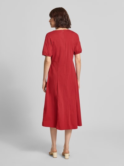 Frauenmodel trägt Midikleid mit Rundhalsausschnitt von MORE & MORE in Rot, Baumwoll-Mix mit Stretch, A-Linie, Rückansicht Ganzkörperansicht.
