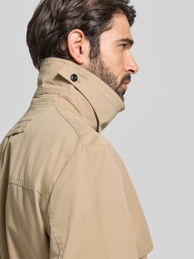 Männermodel draagt Regular Fit Trenchcoat met gun flap model 'MALUKS2511' van HUGO, look: effen, detailopname schouderpartij.