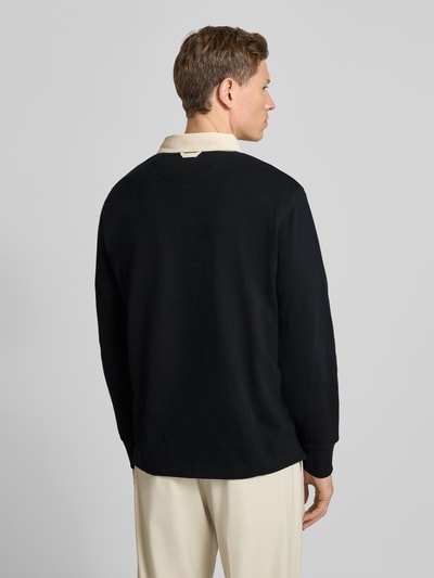 Männermodel trägt Sweatshirt mit Polokragen und verdeckter Knopfleiste von Gant aus reiner Baumwolle, Regular-Fit, Rückenlänge 69 cm, Ärmellänge 66 cm, schwarzer Stoff, Label-Stitching, Ganzkörperansicht Rückansicht.