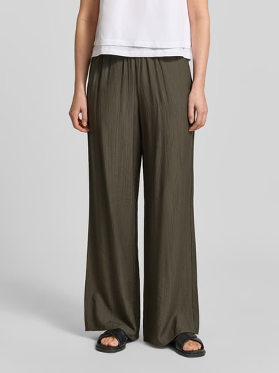 Frauenmodel trägt Wide Fit Stoffhose aus Viskose-Mix Modell 'Marou' von OPUS, olive mit Strukturmuster, elastischer Bund, Nahaufnahme Oberkörper. Kontext: Damen Stoffhose, Strukturmuster, elastischer Bund mit Tunnelzug, Bundweite bei Größe 36: 113 cm, Innenbeinlänge 78 cm.