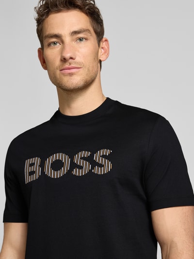 Männermodel trägt Regular Fit T-Shirt aus reiner Baumwolle Modell 'C-THOMPSON 41' von BOSS in Optik: Unifarben mit Label-Stitching-Applikation, Rundhals, Kurzarm und merzerisierter Materialverarbeitung, Nahaufnahme Oberkörper.