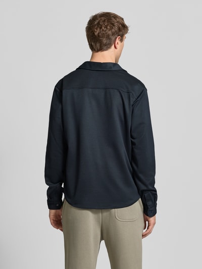 Männermodel trägt Regular Fit Freizeithemd mit Kentkragen Modell 'ADRIAN' von Blend in Schwarz, elastischer Material-Mix, Ganzkörperansicht Rückansicht