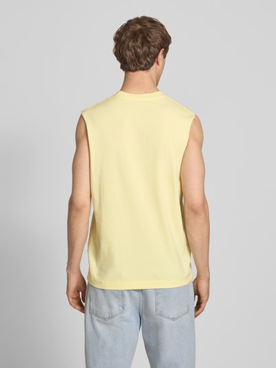 Männermodel trägt T-Shirt mit Stitching von Jack & Jones in Gelb aus Reine Baumwolle, Relaxed-Fit, Rückenlänge 69 cm, Ganzkörperansicht Rückansicht.