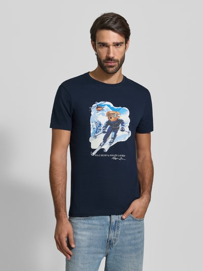 Männermodel trägt T-Shirt mit Label-Print von Polo Ralph Lauren, dunkelblau, aus Baumwolle, Slim Fit, mit Printmotiv, Ganzkörperansicht von vorne.