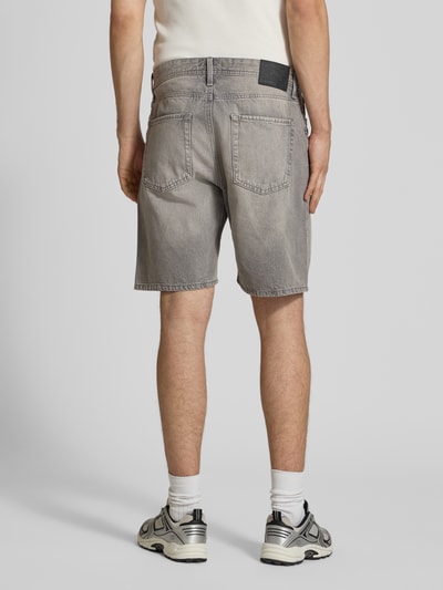 Männermodel trägt Loose Fit Jeansshorts mit Eingrifftaschen Modell 'TONY' von Jack & Jones in grauem Used-Look, Reine Baumwolle, Ganzkörperansicht Rückansicht.