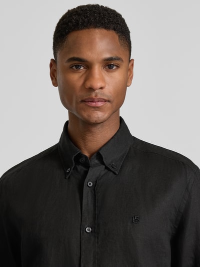Männermodel trägt Regular Fit Freizeithemd aus reinem Leinen Modell 'LIAM' von BOSS in Schwarz, Nahaufnahme Oberkörper.
