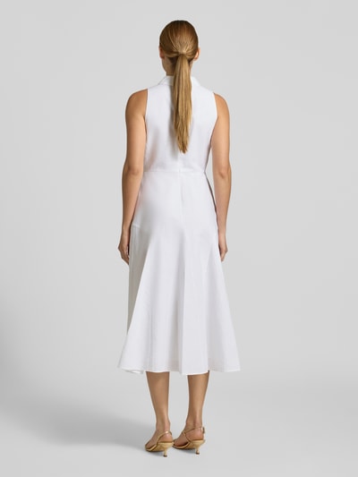 Frauenmodel trägt weißes Midikleid mit Umlegekragen Modell 'Meeha' von Ted Baker im Materialmix, Ganzkörperansicht Rückansicht.