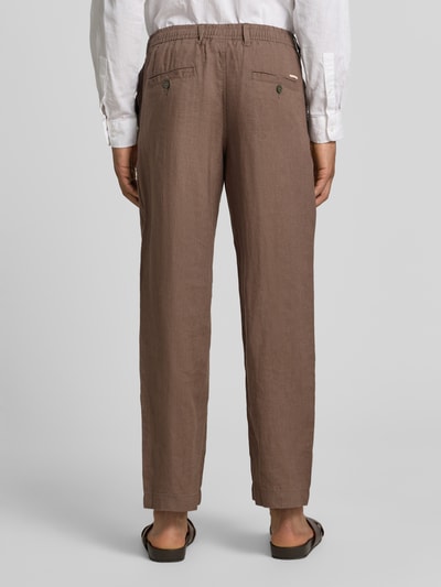 Männermodel trägt Leinenhose mit Eingrifftaschen Modell 'KARL LAWRENCE' von Jack & Jones Premium, braun, Reines Leinen, Straight Fit, Ganzkörperansicht Rückansicht.