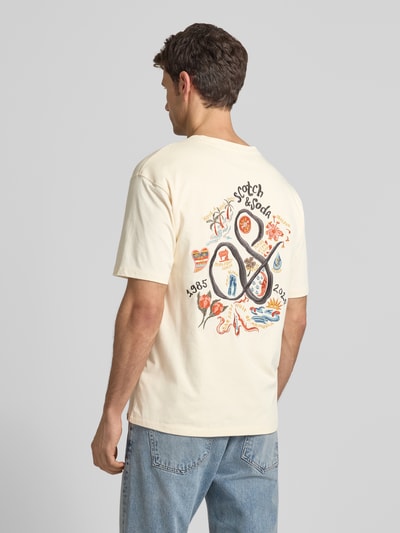 Männermodel trägt T-Shirt mit Label-Stitching von Scotch & Soda in Beige, reine Baumwolle, Regular-Fit, Rückenlänge 70 cm, Ganzkörperansicht Rückansicht.