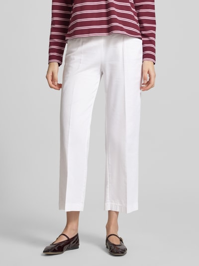 Frauenmodel trägt Wide Fit Stoffhose in 7/8-Länge Modell 'Sue' von TONI aus Baumwoll-Mix mit Bügelfalten, Tunnelzug und Eingrifftaschen, Ganzkörperansicht von vorne.