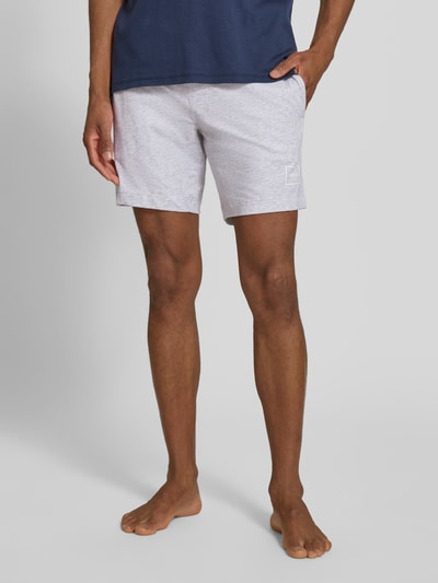 Männermodel trägt Regular Fit Sweatshorts aus Baumwoll-Mix Modell 'LAZE SHORTS CW' von HUGO, hellgrau, unifarben, Label Print, Ganzkörperansicht von vorne.