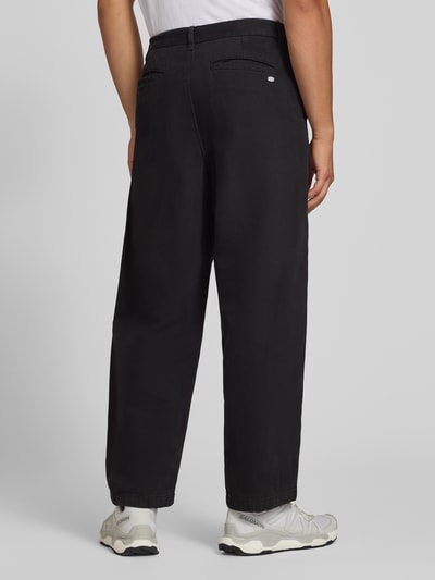 Mężczyznamodel trägt Straight Fit Jeans aus reiner Baumwolle von REVIEW w kolorze czarnym, wpuszczane kieszenie, zapięcie na guzik i zamek błyskawiczny, szerokość w rozmiarze M: 44 cm, długość wewnętrzna nogawki w rozmiarze M: 74 cm, tekstura gładka, całkowity widok z tyłu.
