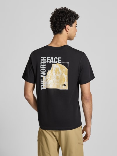 Männermodel trägt Regular Fit T-Shirt mit Logo-Print von The North Face aus Baumwoll-Mix, schwarzer Stoff, Rückenlänge 69 cm, Ganzkörperansicht Rückansicht.