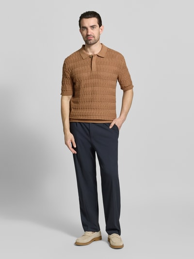 Männermodel trägt Regular Fit Poloshirt mit Strukturmuster von Scotch & Soda aus reiner Baumwolle, Polokragen, verdeckte Knopfleiste, Herrenmode, Ganzkörperansicht von vorne.