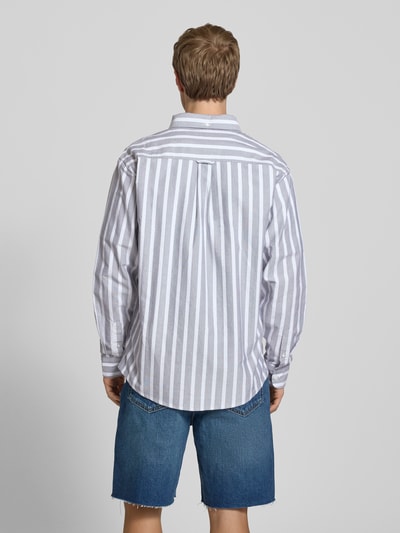Männermodel trägt Regular Fit Freizeithemd mit Logo-Stitching Modell 'Deven' von Carhartt Work In Progress, gestreift, Reine Baumwolle, Langärmelig, Button-Down-Kragen, Knopfleiste, Sportmanschetten, Ganzkörperansicht Rückansicht.