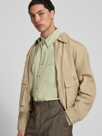 Männermodel trägt Freizeithemd aus reinem Lyocell von Filippa K in Hellgrün mit Brusttasche, Button-Down-Kragen, Relaxed-Fit, Langärmelig, Ganzkörperansicht von vorne. Rückenlänge bei Größe 50: 72 cm, Schulterbreite 48 cm, Ärmellänge 70 cm.