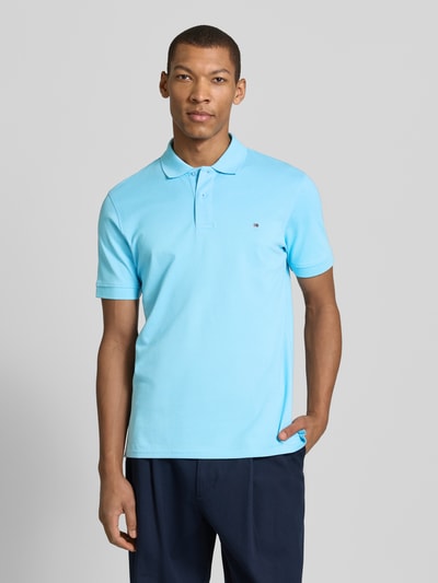Męski model nosi Regular Fit Poloshirt mit Stitching od Christian Berg Men, czysta bawełna, krój regular fit, jasnoniebieski kolor, zapięcie na guziki, gładka faktura, widok całej sylwetki z przodu.