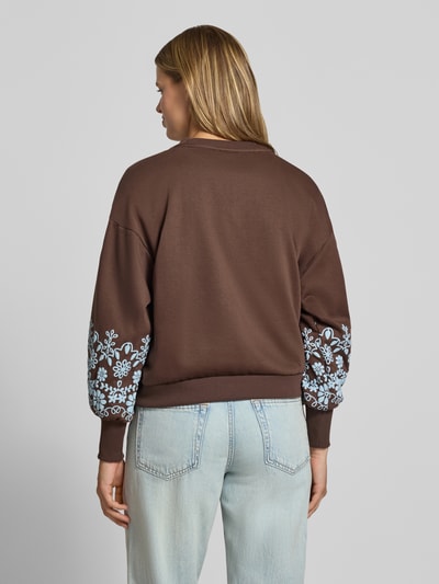 Frauenmodel trägt Relaxed Fit Sweatshirt aus reiner Baumwoll-Mix Modell 'BROOKE' von ONLY, braun mit hellblauem Blumenmuster, Damen Sweatshirt, Ganzkörperansicht Rückansicht