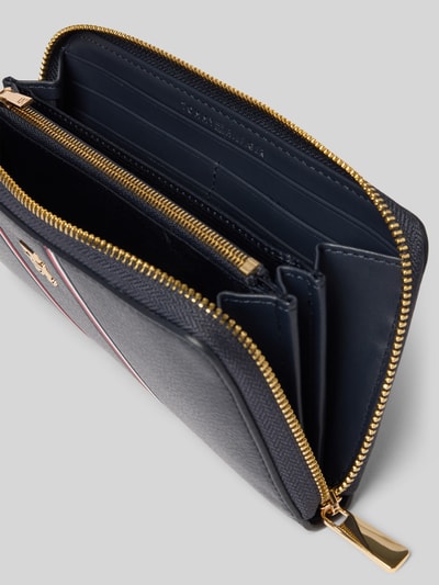 Produktfoto, Portemonnaie aus Lederoptik von Tommy Hilfiger, Optik: unifarben, Reißverschluss, Münzfach, Kartenfächer, Geldscheinfächer, Logo-Applikation aus Metall, Kontraststreifen, strukturierte Oberfläche, dunkle Töne, goldene Details
