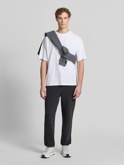 Männermodel trägt Sweatpants mit Eingrifftaschen Modell 'ATUBAY' von American Vintage in Schwarz, Relaxed-Fit, Baumwoll-Elasthan-Mix, Ganzkörperansicht von vorne.