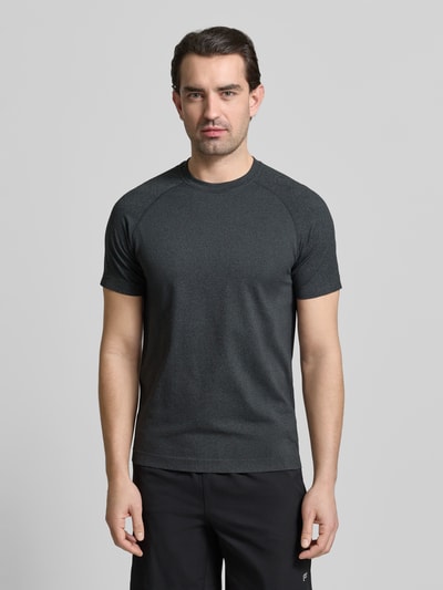 Męski model nosi Regular Fit T-Shirt mit Rundhalsausschnitt von Fabletics, ciemnoszare, z logo, krój regular fit, krótkie rękawy, długość pleców w rozmiarze M: 69 cm, widok całej sylwetki od przodu.