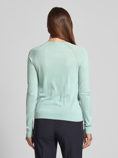 Modelka nosi Regular Fit Strickjacke aus reiner Schurwolle Modell 'FONAMI' von BOSS, efekt: jednolity kolor, drobny splot, czysta żywa wełna, raglanowe rękawy, prążkowane wykończenie, okrągły dekolt, listwa guzikowa, długi rękaw; widok całej sylwetki od tyłu.