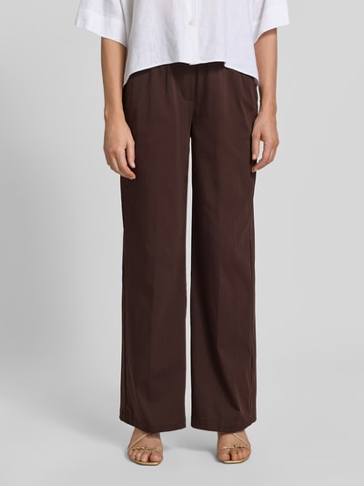 Kobiece model prezentuje spodnie materiałowe z mieszanki bawełny z dodatkiem streczu OPUS PANTS, krój loose fit, model 'Mucia Base', ciemnobrązowy, wpuszczane kieszenie z przodu, kieszenie z wypustką z tyłu, elastyczny pas, szerokość w rozmiarze 36: 31 cm, długość wewnętrzna nogawki w rozmiarze 36: 80 cm, zdjęcie: całkowity widok z przodu.