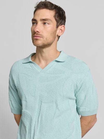 Männermodel trägt Relaxed Fit Poloshirt aus reiner Baumwolle Modell 'ASURFO' von BOSS Orange, Optik: Unifarben, Struktur, Nahaufnahme Oberkörper.