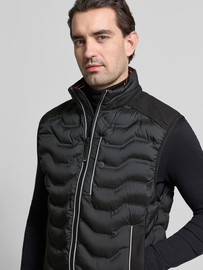 Männermodel trägt Regular Fit Steppweste mit Kapuze im Kragen von Tom Tailor, unifarben, reflektierende Details, Nahaufnahme Oberkörper.