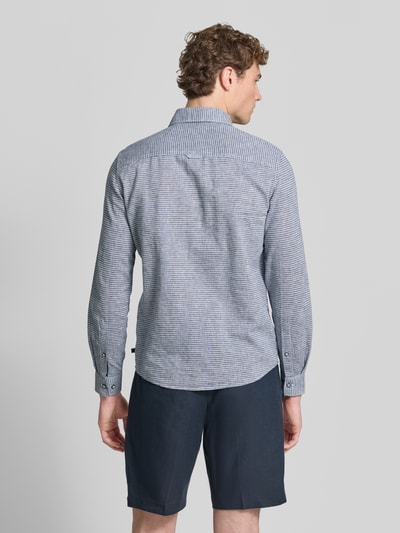 Männermodel trägt Regular Fit Freizeithemd aus Leinen-Baumwoll-Mix von s.Oliver RED LABEL mit allover-muster, sportmanschetten, ganzkörperansicht rückansicht.
