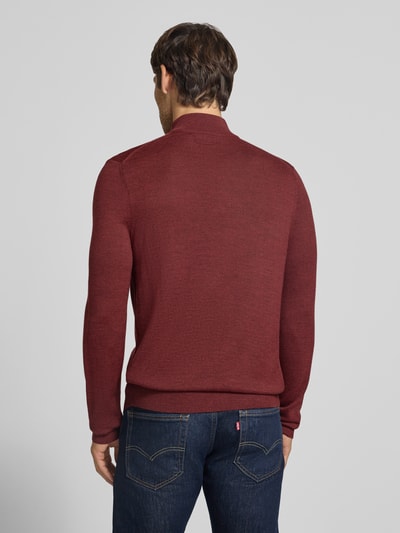 Männermodel trägt Slim Fit Strickpullover aus wolmix mit schipperskraag von Christian Berg Men in wijnrood, ruglengte maat M 72 cm, mouwlengte maat M 69 cm, elastische boordjes, ganzkörperansicht rückansicht.