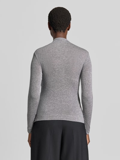 Frauenmodel trägt Longsleeve in Wickel-Optik von windsor., melierte Optik in Grau, taillierter Schnitt, Ganzkörperansicht Rückansicht. Elastischer Lyocell-Woll-Mix, Rückenlänge 58 cm bei Größe 36, Label-Applikation sichtbar.