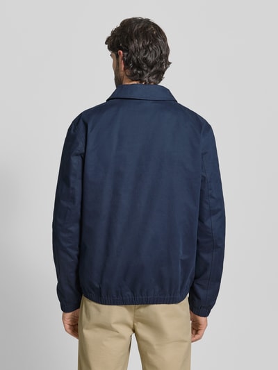 Männermodel trägt dunkelblaue Regular Fit Jacke mit Umlegekragen von MCNEAL, Material-Mix, elastische Abschlüsse, Ganzkörperansicht Rückansicht.