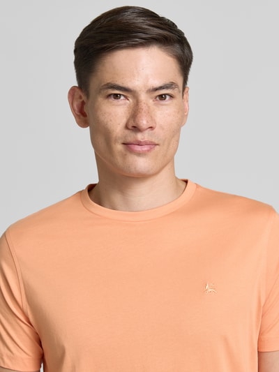 Männermodel trägt T-shirt met ronde hals en gestikt logo van Lerros in effen perzikkleur, puur katoen, regular fit, ruglengte maat M 77 cm, Nahaufnahme Oberkörper.