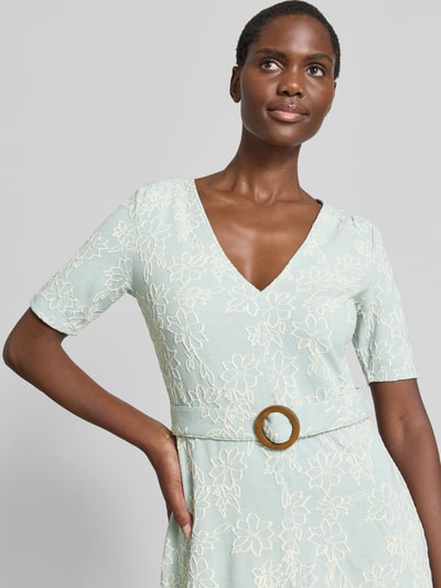 Vrouwenmodel draagt Midikleid met V-hals en riem van Zero, materiaalmix met viscose, getailleerd model, borstwijdte maat 36: 46 cm, ruglengte: 111 cm, mouwlengte: 26 cm, lichtgroen met geborduurde bloemmotieven, detailopname bovenlichaam.