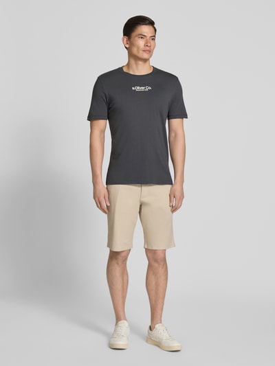 Männermodel trägt Regular Fit T-Shirt aus reiner Baumwolle von s.Oliver RED LABEL, unifarben, Jersey, Label-Schriftzug, Ganzkörperansicht von vorne.