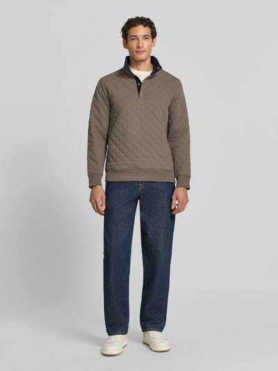 Männermodel trägt Regular Fit Troyer aus Baumwoll-Mix von GANT in taupe mit Stehkragen, Strukturmuster, Langarm, Ganzkörperansicht von vorne.