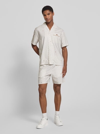 Mężczyzna nosi Regular Fit Chinoshorts aus Baumwoll-Viskose-Mix model 'Aop Short Tenniscourt' von Lacoste, jasne kolory, wzór, Herren Chinoshorts von Lacoste, Ganzkörperansicht von vorne.