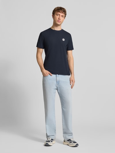 Mężczyzna model nosi Regular Fit T-Shirt mit Strukturmuster Modell 'Kaito' od Blend, bawełna, krój regular fit, okrągły dekolt, logo, długość tyłu w rozmiarze M: 71 cm, granatowy, widok całej sylwetki z przodu.
