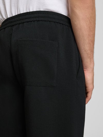 Männermodel trägt Loose Fit Shorts mit elastischem Bund Modell 'WILL' von Only & Sons, Optik: Unifarben, Gesäßtasche, Detailaufnahme Rücken.