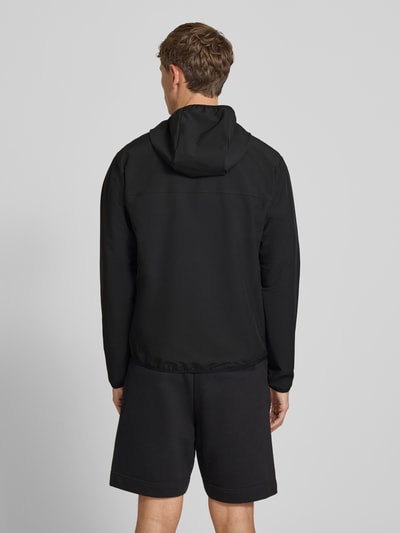 Mężczyznamodel nosi kurtkę treningową Regular Fit Trainingsjacke mit Kapuze Modell 'LW_COMMUTERPRO' von BOSS Green, czarny kolor, gładka tekstura, widok całej sylwetki z tyłu.