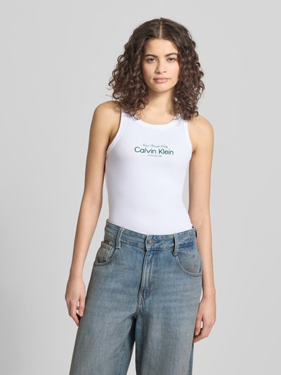 Modelka nosi Top mit Label-Stitching Modell 'CONTOUR' od Calvin Klein Jeans, mieszanka bawełny, dopasowany krój, dekolt w łódkę, długość tyłu w rozmiarze S: 48 cm, wyhaftowane logo; widok całej sylwetki z przodu.