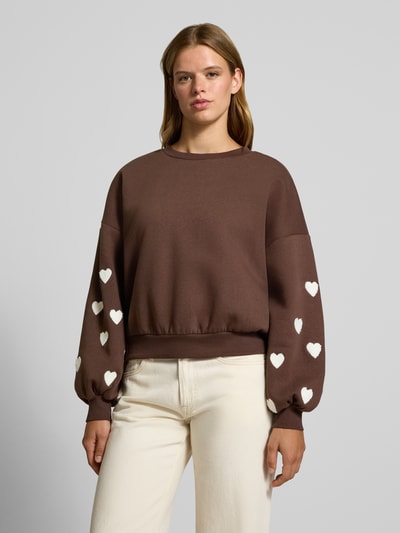 Vrouwenmodel draagt Regular fit sweatshirt uit katoenmix model 'MACY' van ONLY, bruin met witte hartjes, Dames sweatshirt, frontale busteshot.
