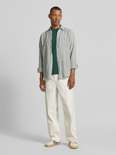 Męski model nosi zielony t-shirt Relaxed Fit T-Shirt aus reiner Baumwolle Modell 'ASPEN' von SELECTED HOMME, prosta faktura, Ganzkörperansicht von vorne.