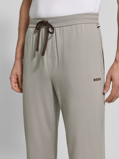 Männermodel trägt Regular Fit Sweathose aus Baumwoll-Mix Modell 'Mix&Match Pants' von BOSS in Hellgrau mit sichtbarer Kordel, Nahaufnahme Oberkörper, Herren Sweathose von BOSS.