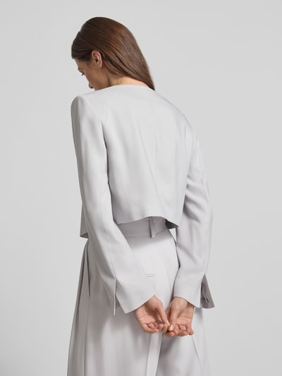 Frauenmodel trägt Asymmetrisch geschnittener cropped Blazer-curated by Vicky Heiler von SIC in hellem Viskose-Elasthan-Mix, fließende Textur, Knopfverschluss, Rückansicht, Ganzkörperansicht